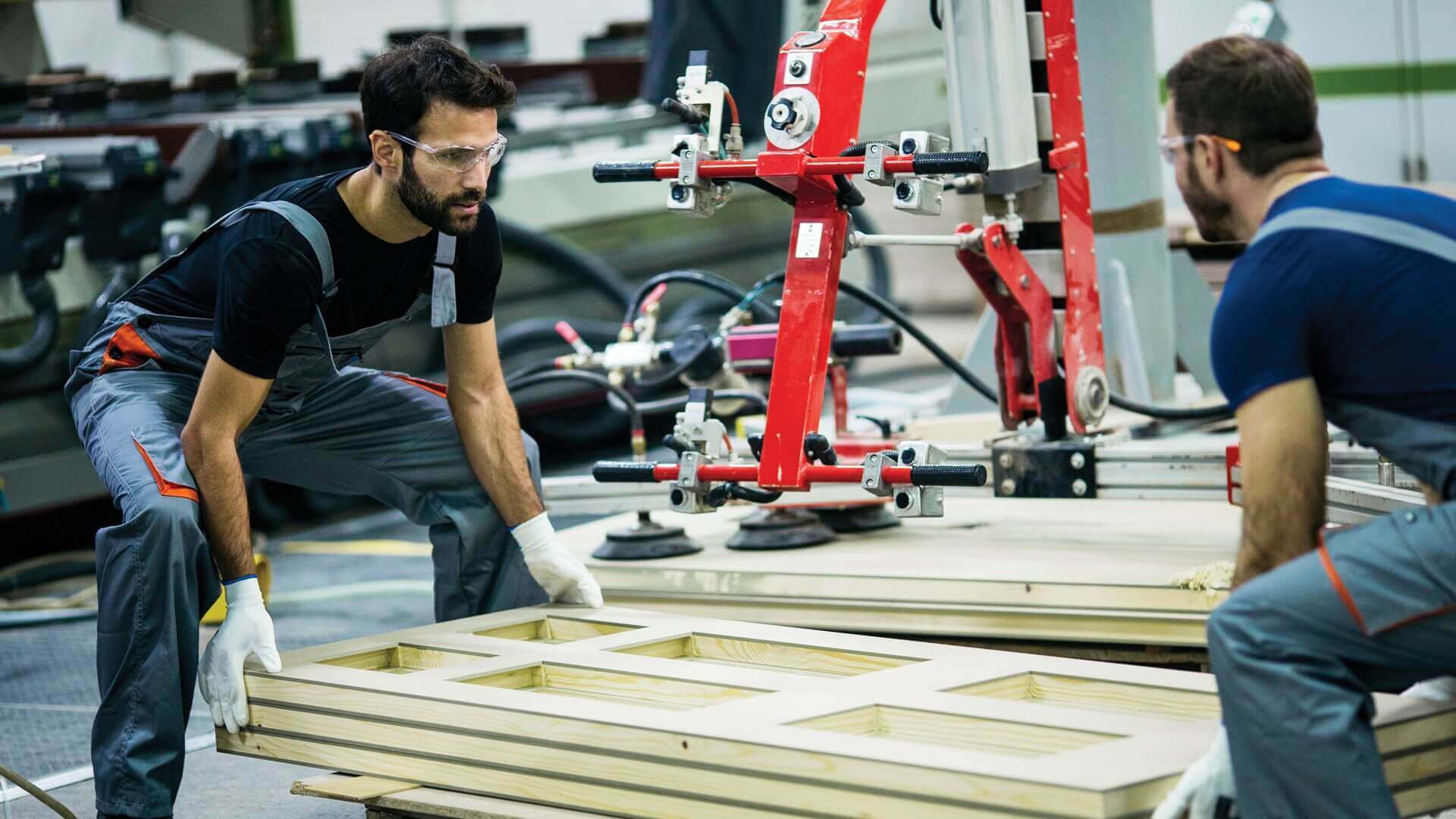 Two men lifting heavy frames